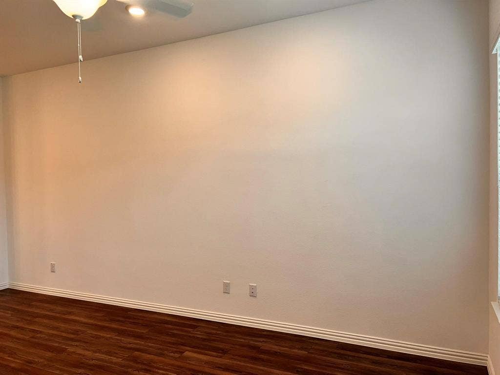 1054 Old Rosebud Drive, Allen, TX 75013 Spacious room featuring wood-finish flooring, white baseboards, and a ceiling fan with integrated lighting