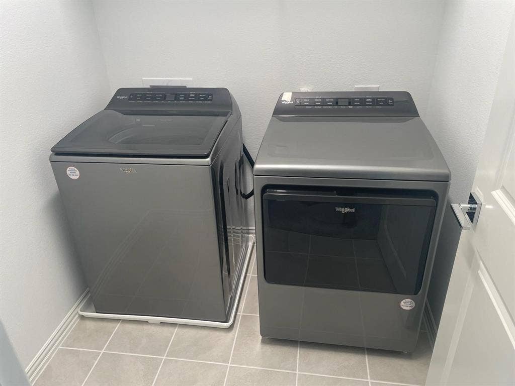 1054 Old Rosebud Drive, Allen, TX 75013 Dedicated laundry area featuring a top-load washer and front-load dryer in a neutral finish