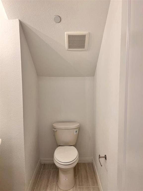 1054 Old Rosebud Drive, Allen, TX 75013 Powder room featuring a single toilet, wood-look tile flooring, and a ceiling-mounted exhaust fan
