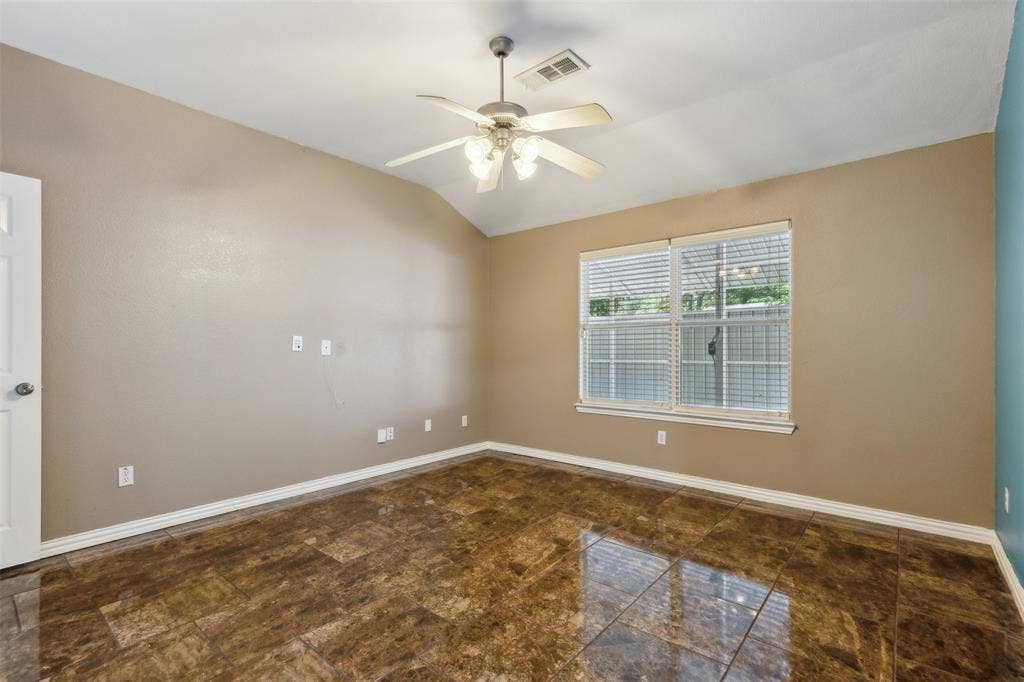 8614 Torreon Court, Dallas, TX 75217 Empty room with tile flooring, lofted ceiling, and ceiling fan