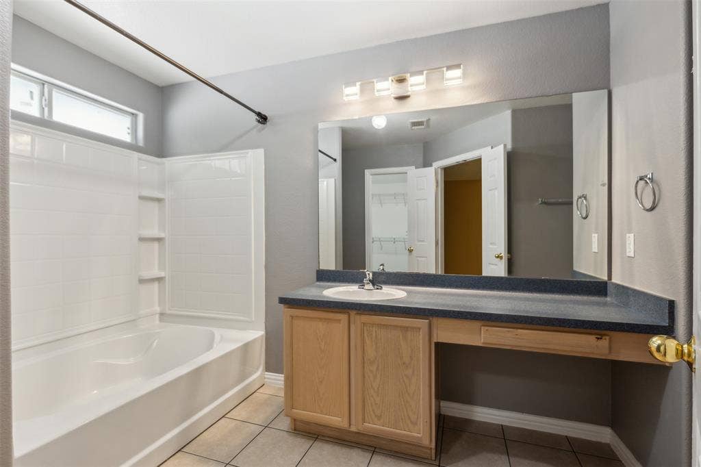 8614 Torreon Court, Dallas, TX 75217 Bathroom with bathing tub / shower combination, tile flooring, and vanity with extensive cabinet space