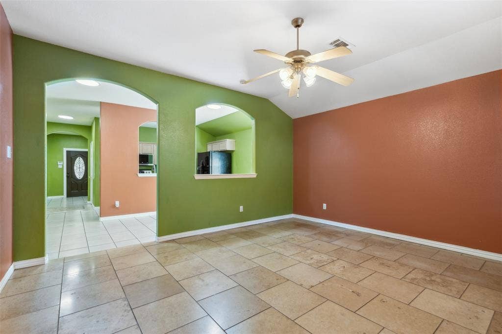 8614 Torreon Court, Dallas, TX 75217 Unfurnished room with vaulted ceiling, ceiling fan, and light tile floors