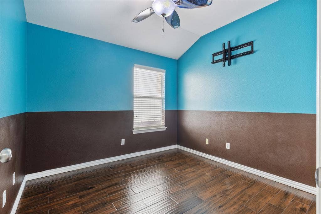 8614 Torreon Court, Dallas, TX 75217 Empty room featuring dark hardwood / wood-style flooring, ceiling fan, and lofted ceiling
