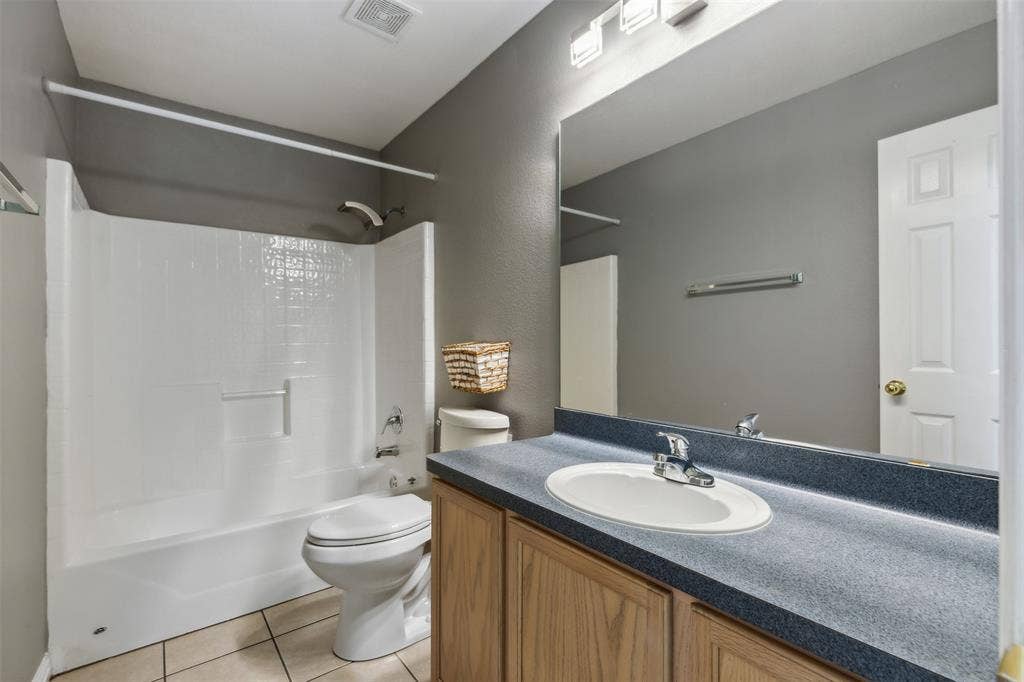 8614 Torreon Court, Dallas, TX 75217 Full bathroom featuring tile flooring, shower / bathing tub combination, toilet, and vanity