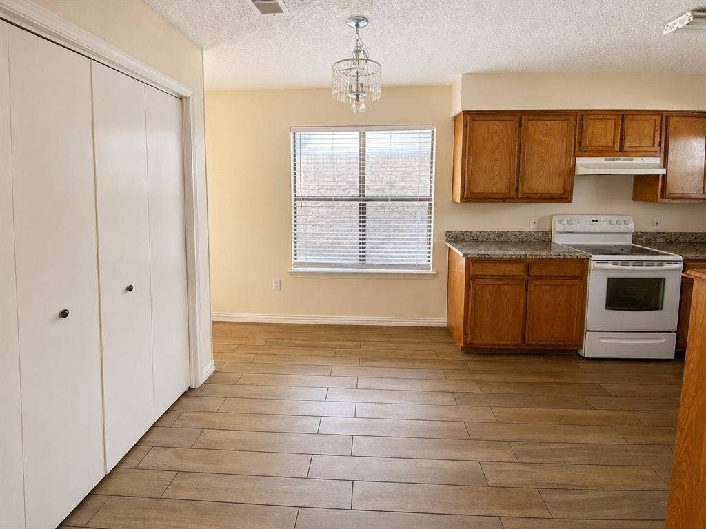 530 Rawls Circle, Irving, TX 75061 Kitchen space featuring wood-finish flooring, oak cabinetry, and granite-look countertops