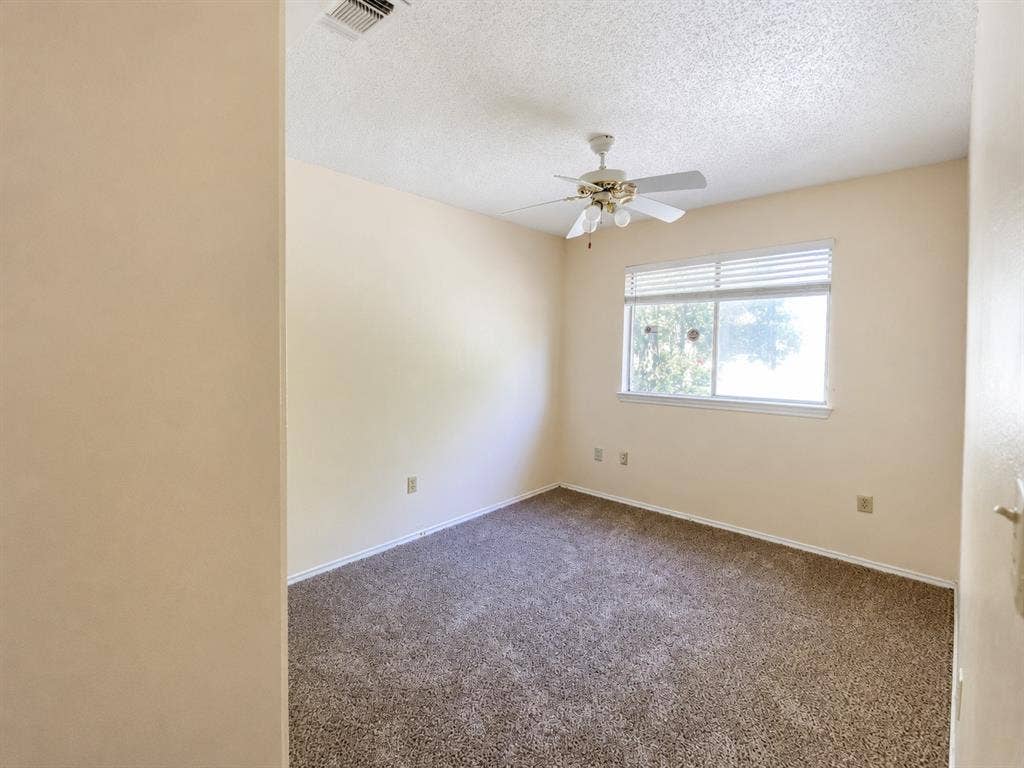 530 Rawls Circle, Irving, TX 75061 Carpeted room featuring a window with horizontal blinds, a ceiling fan with integrated lighting, and neutral-toned walls