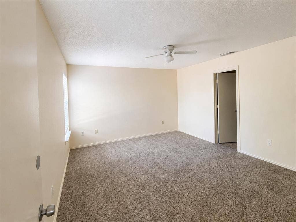 530 Rawls Circle, Irving, TX 75061 Spacious room featuring new carpet, a ceiling fan, and ample natural light from the window