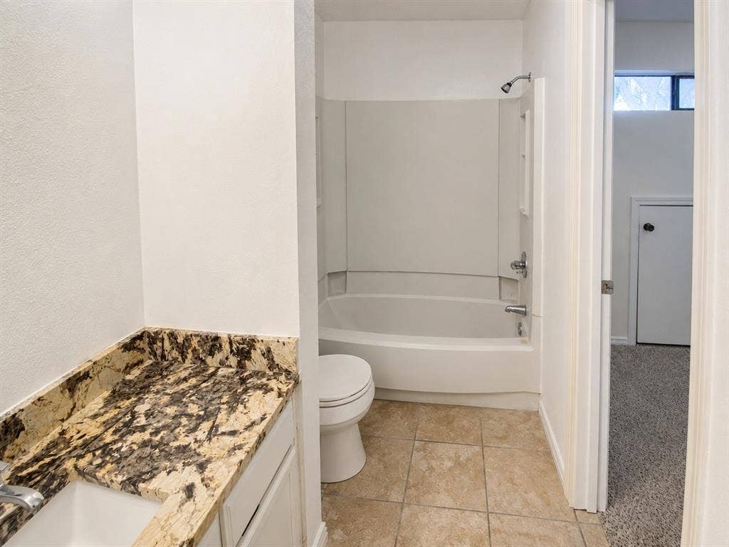 530 Rawls Circle, Irving, TX 75061 Bathroom featuring a vanity with a patterned stone countertop, an integrated sink, and white cabinetry
