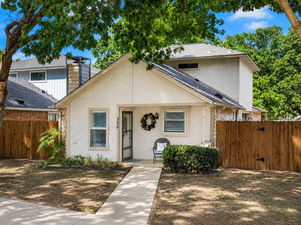 530 Rawls Circle, Irving, TX 75061 Gable roofline property featuring a front walkway, established trees, and wood fencing