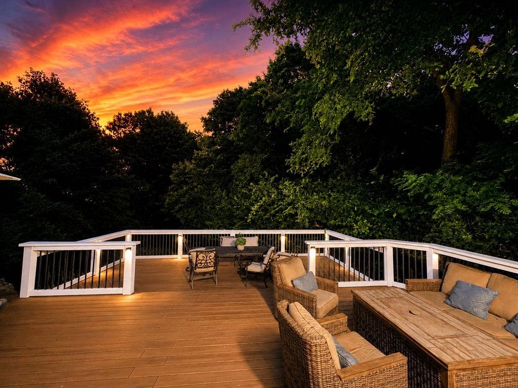 Expansive wood-finish deck with white railings and black balusters