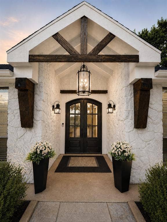 Arched double entry doors feature decorative glass inserts