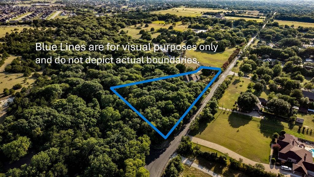 Expansive tree-covered acreage featuring a paved road frontage and surrounded by additional wooded areas