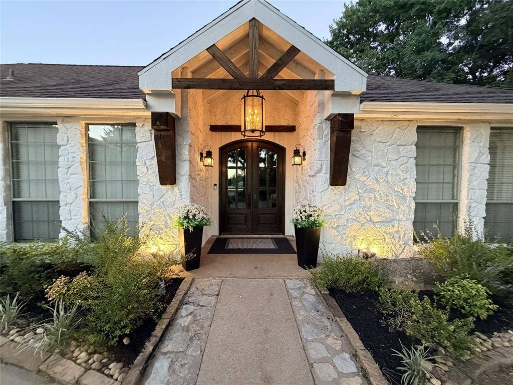 Stone exterior featuring a prominent arched double-door entry