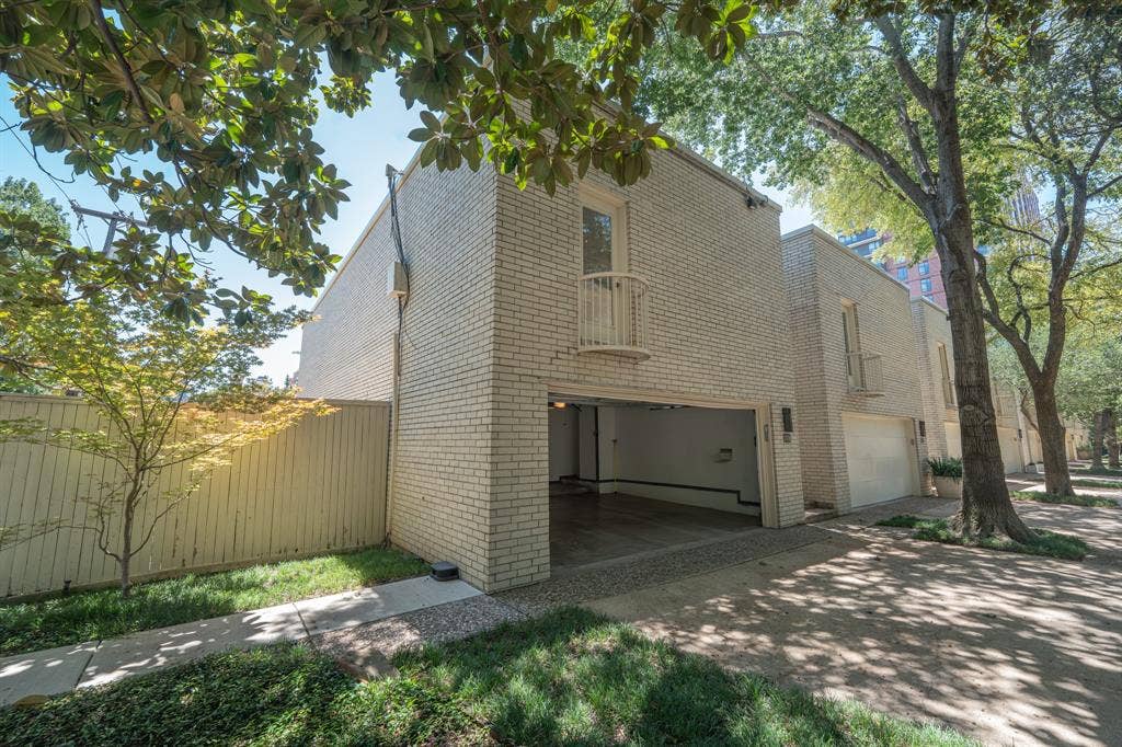 2818 Welborn Drive, #9, Dallas, TX 75219 Cream brick exterior featuring an integrated two-car garage