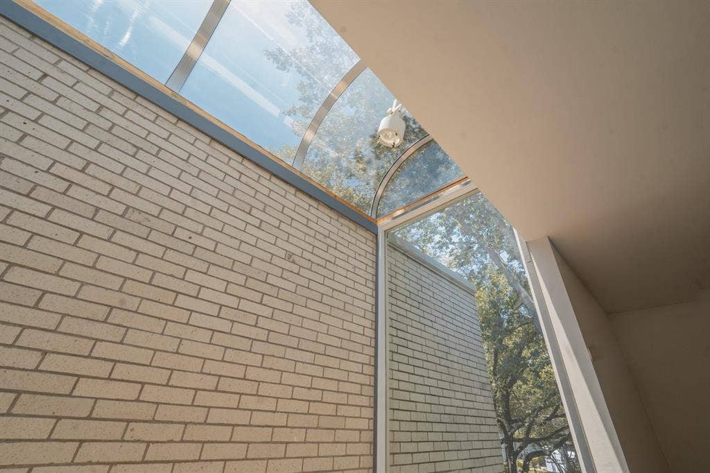 2818 Welborn Drive, #9, Dallas, TX 75219 Arched glass skylight and window system with exposed light-colored brick and smooth finished walls