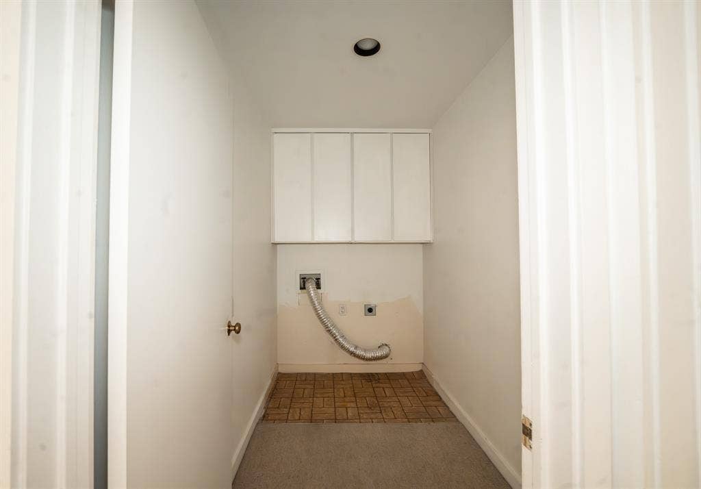 2818 Welborn Drive, #9, Dallas, TX 75219 Dedicated laundry area featuring upper white cabinetry, a recessed ceiling light, and a combination of carpet and brown tile flooring