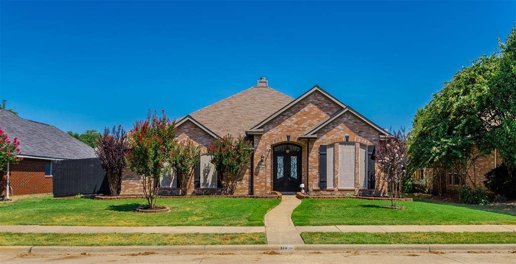 11404 Amber Valley Drive, Frisco, TX 75035 Brick exterior with arched entry, gabled roofline, and established landscaping