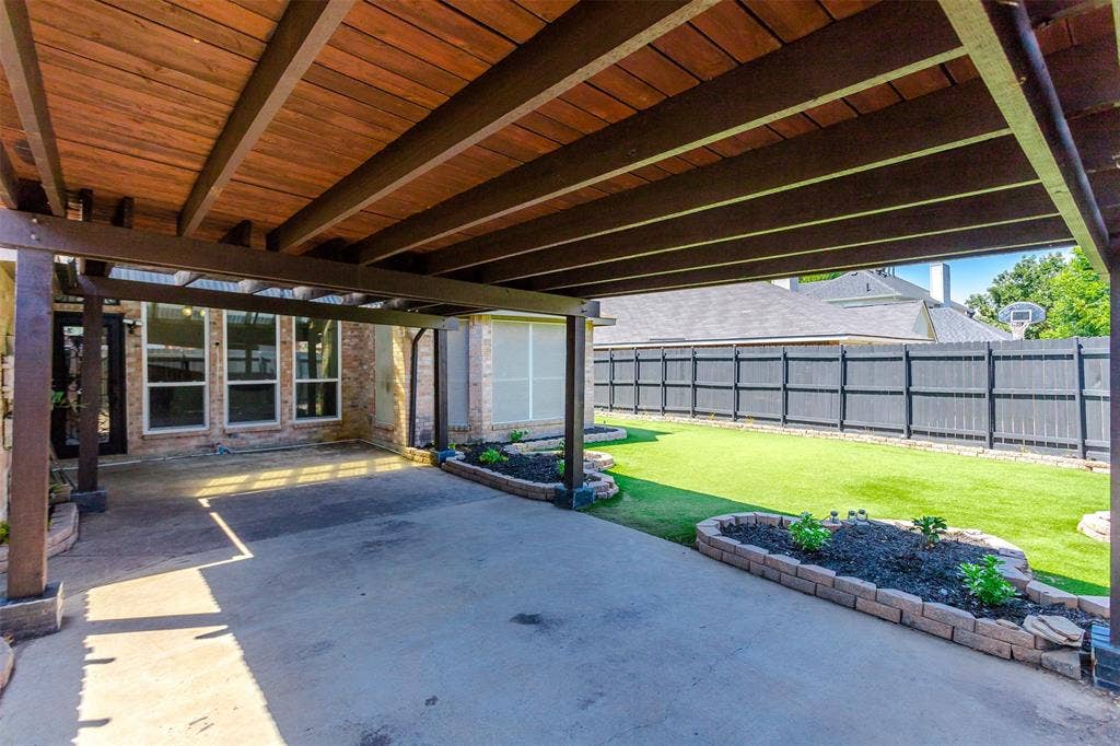 11404 Amber Valley Drive, Frisco, TX 75035 Covered patio featuring a wood-finish ceiling, concrete flooring, and brick-edged planter beds
