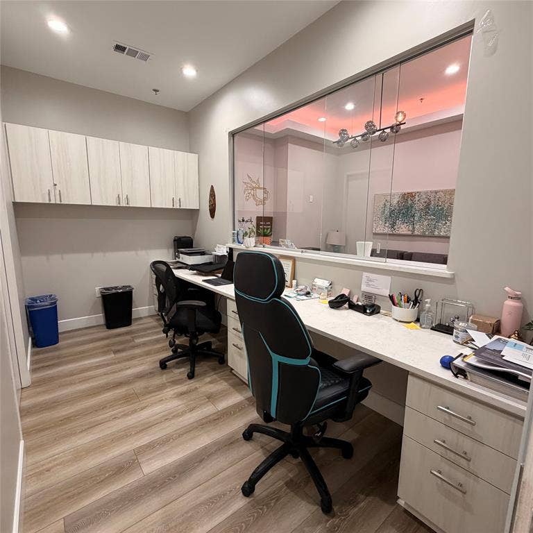 945 Stockton Drive, #7120, Allen, TX 75013 Spacious office area featuring wood-finish flooring, recessed lighting, and a full wall of light-toned cabinetry with silver hardware