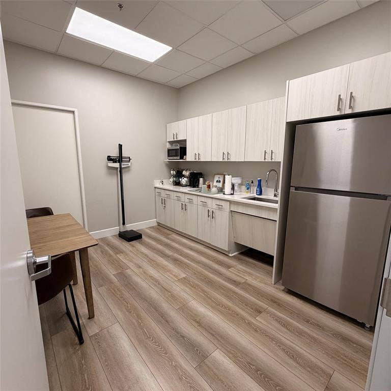 945 Stockton Drive, #7120, Allen, TX 75013 Dedicated kitchen area featuring extensive cabinetry, a built-in stainless steel refrigerator, and wood-finish flooring