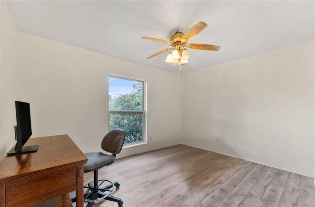 Wood-finish flooring, single window, ceiling fan with light fixture, and neutral wall tones