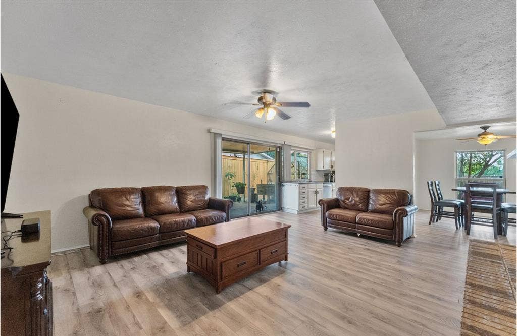 Wood-finish flooring, ceiling fan, sliding glass door, and a dining area