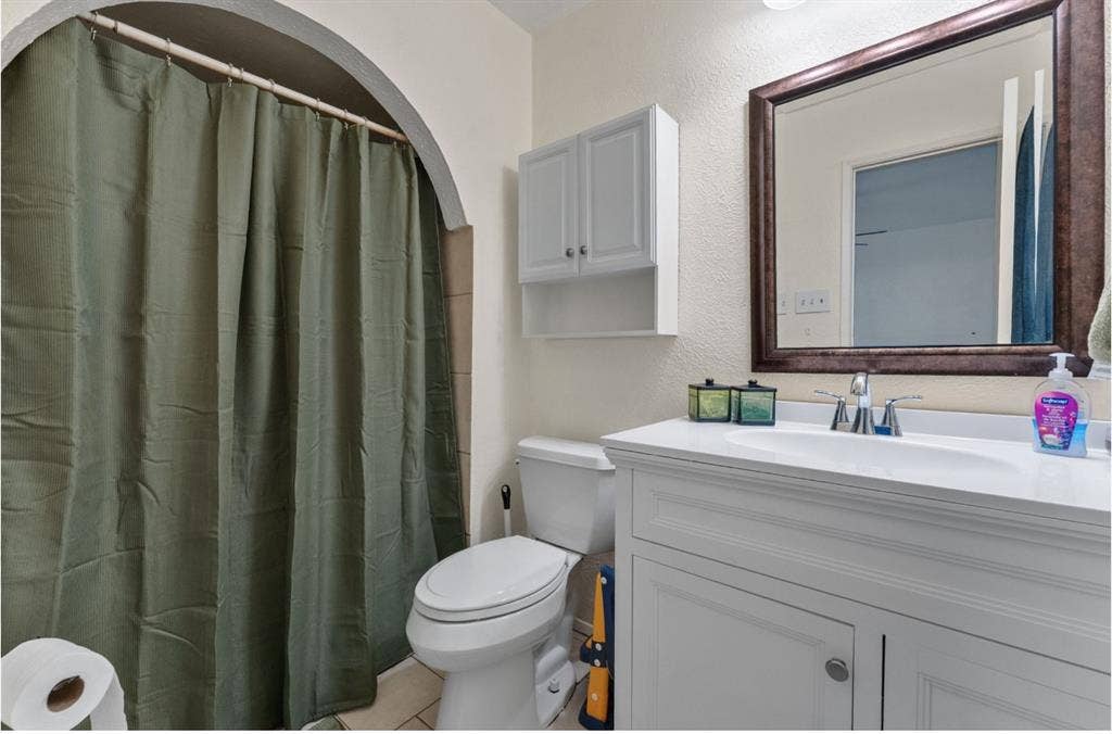 White vanity with integrated sink, framed mirror, and chrome faucet