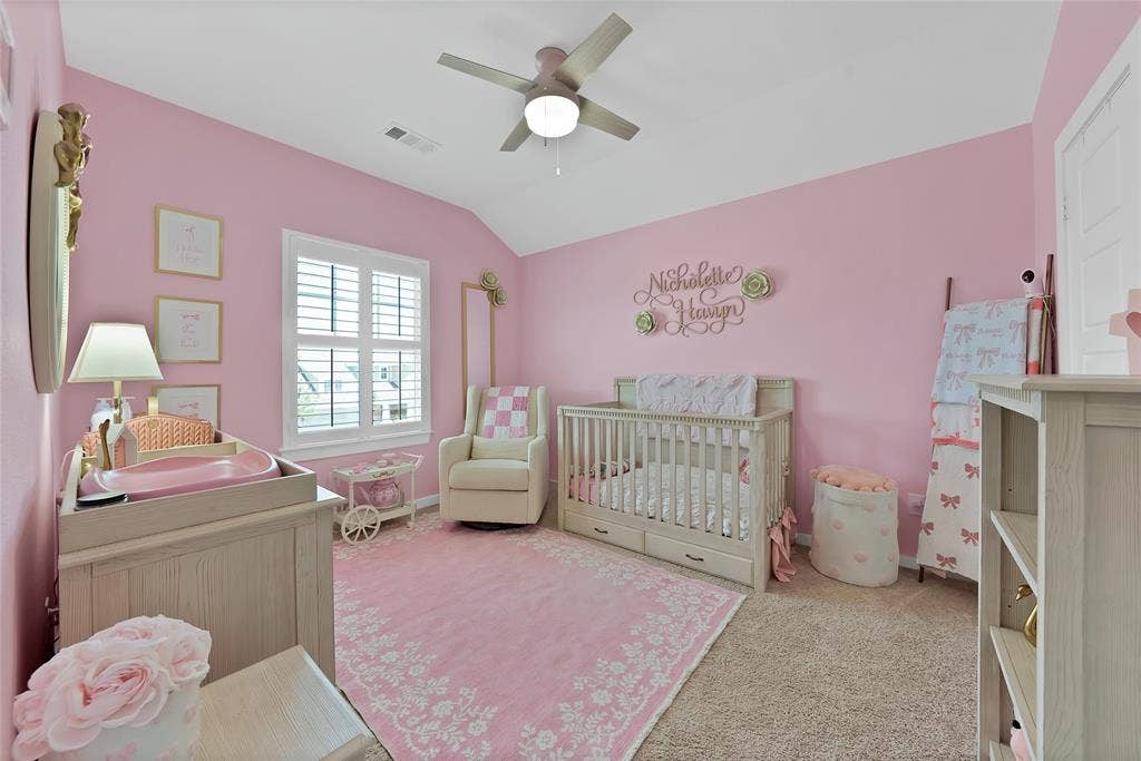 Carpeted room featuring a window with white louvered shutters, a ceiling fan, and painted walls