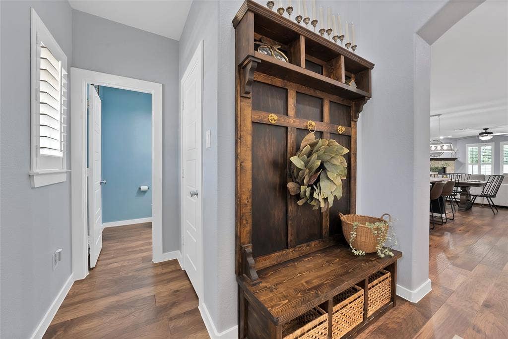 Rich wood-finish flooring throughout, featuring a built-in hall tree with integrated bench and storage