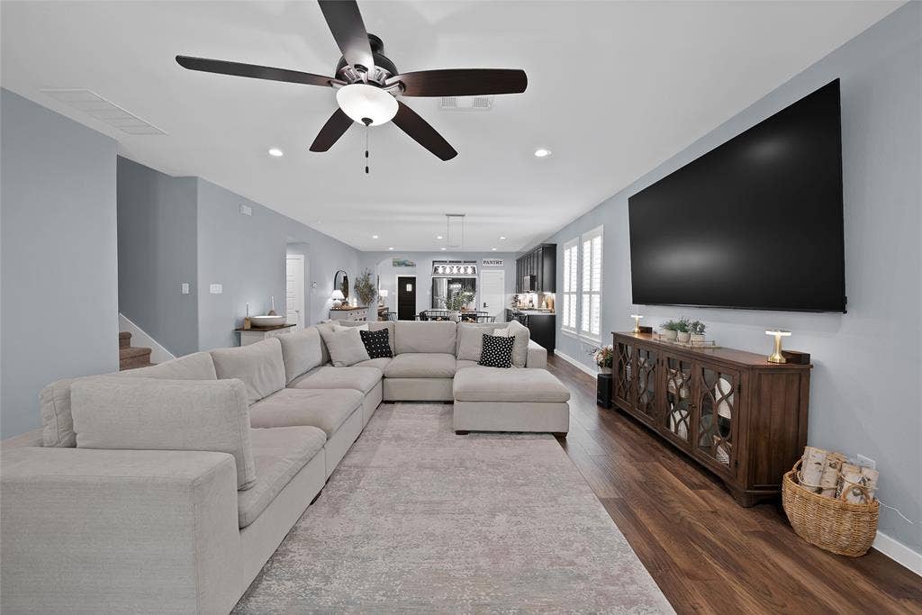 Open-concept living area featuring wood-finish flooring and recessed lighting