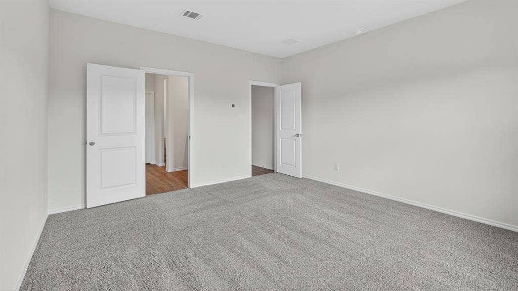 6053 Freedom Drive, Lindale, TX 75771 Spacious room featuring light gray walls, gray carpeting, white baseboards, and two-panel interior doors