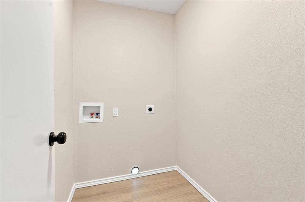 7321 Burke Circle, Plano, TX 75025 Utility connections for laundry appliances, wood-finish flooring, and light-toned walls