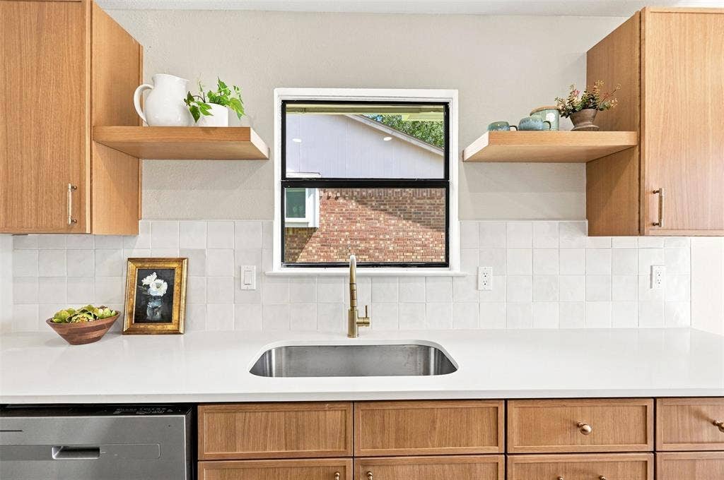 7321 Burke Circle, Plano, TX 75025 Stainless steel sink with a gold-tone faucet, white countertops, square tile backsplash, and light wood-finish cabinetry