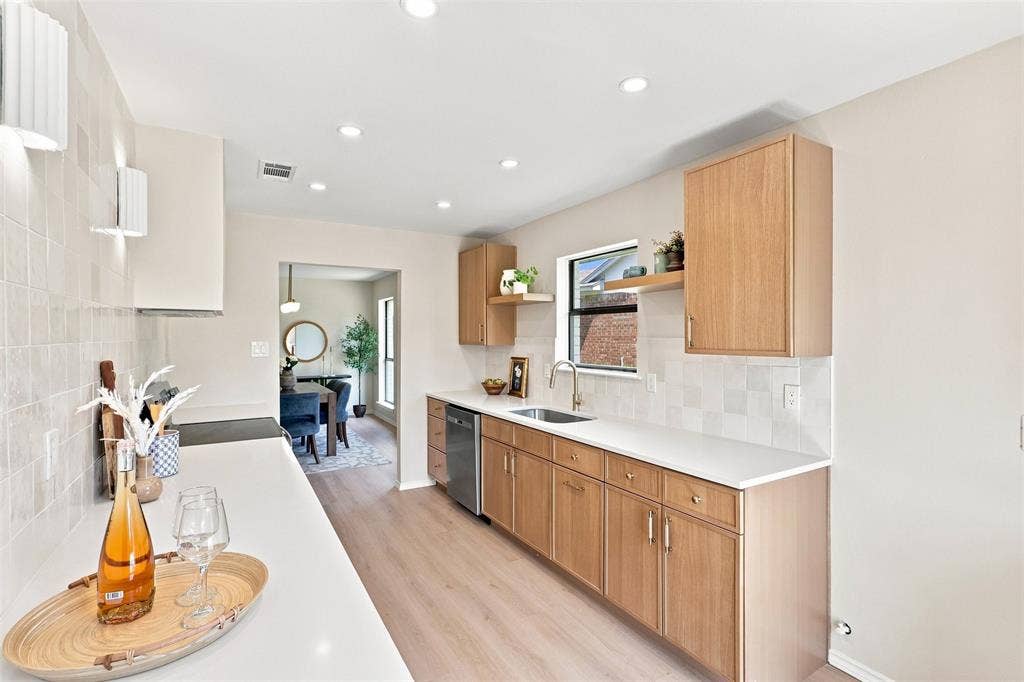 7321 Burke Circle, Plano, TX 75025 Wood-finish cabinetry, light-toned countertops, tile backsplash, built-in stainless steel dishwasher, and recessed lighting