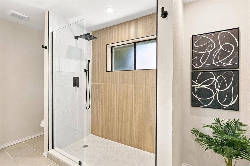 7321 Burke Circle, Plano, TX 75025 Glass-enclosed shower with matte black fixtures, rain shower head, and an integrated shower wand