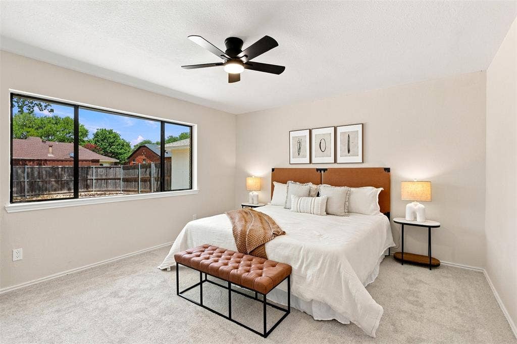 7321 Burke Circle, Plano, TX 75025 Light-colored carpeted flooring, a wide window with dark framing, and a ceiling fan with black blades