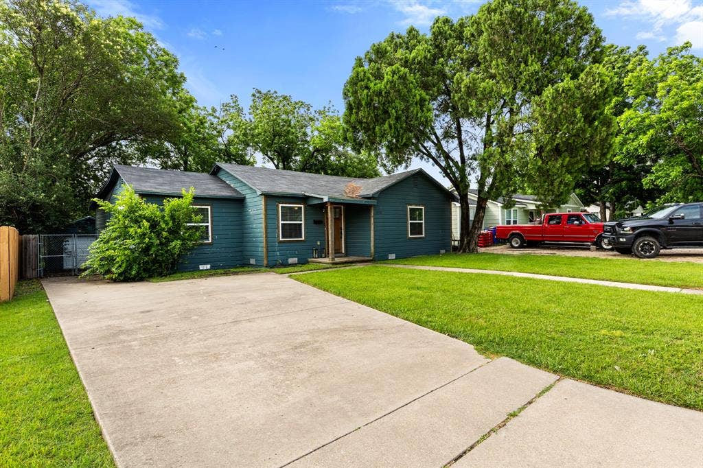 3700 Charlton Avenue, Waco, TX 76711 Single-story residence featuring a dark blue siding exterior, a gray shingle roof, and multiple white-trimmed windows