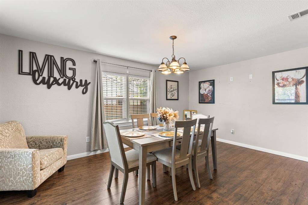 3700 Charlton Avenue, Waco, TX 76711 Dining area featuring wood-finish flooring, neutral wall tones, and a multi-bulb chandelier