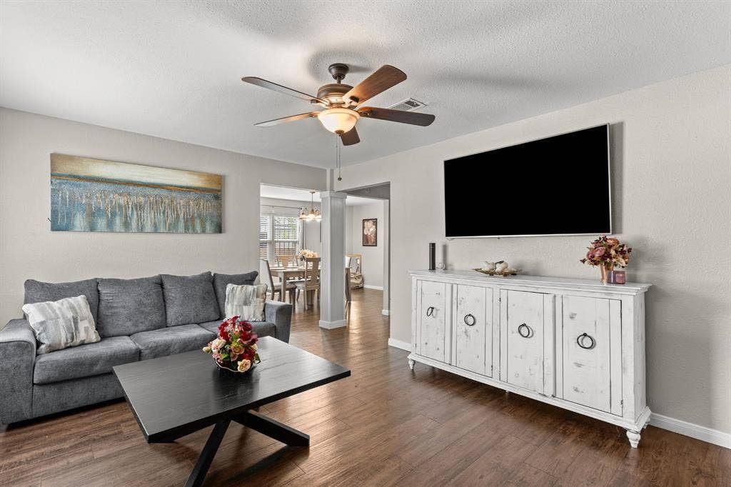3700 Charlton Avenue, Waco, TX 76711 Open-concept living space featuring wood-finish flooring, a ceiling fan with integrated lighting, and neutral wall tones