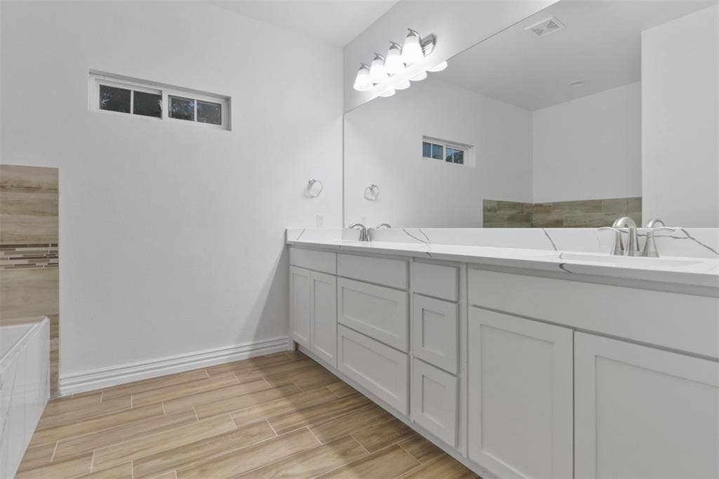 4112 Balch Drive, Dallas, TX 75216 Spa-inspired primary bathroom featuring a double vanity with soft-close cabinetry, dual rectangular sinks, and polished chrome fixtures