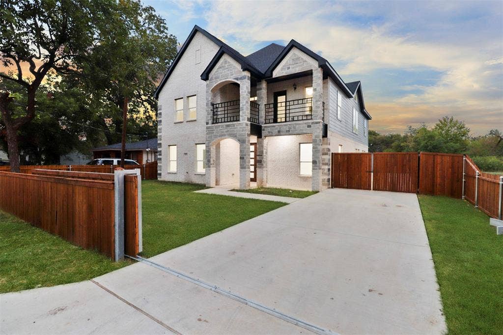4112 Balch Drive, Dallas, TX 75216 Modern two-story residence featuring a striking architectural design with peaked rooflines, white exterior cladding, and dark stone accents