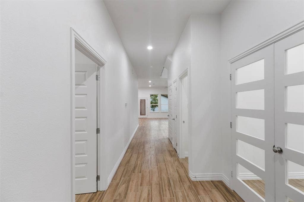 4112 Balch Drive, Dallas, TX 75216 Elongated hallway featuring wood-finish flooring, recessed lighting, and white baseboards