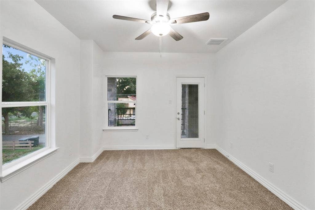 4112 Balch Drive, Dallas, TX 75216 Carpeted room featuring a ceiling fan, two windows, and a glass-paneled door