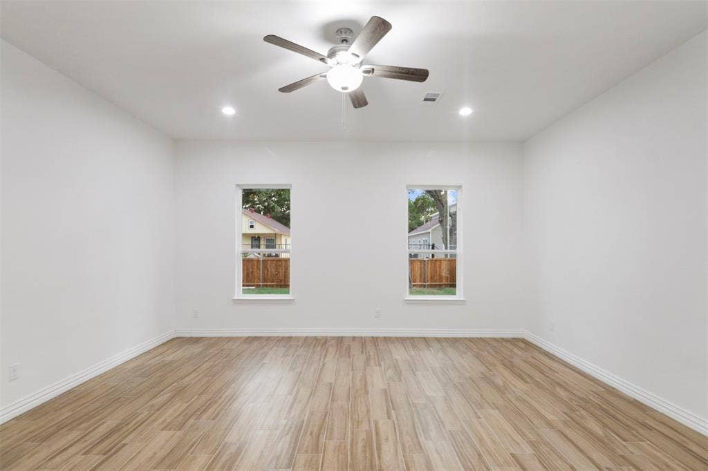 4112 Balch Drive, Dallas, TX 75216 Room featuring wood-finish flooring, two windows, recessed lighting, a ceiling fan with integrated lighting, and white baseboards