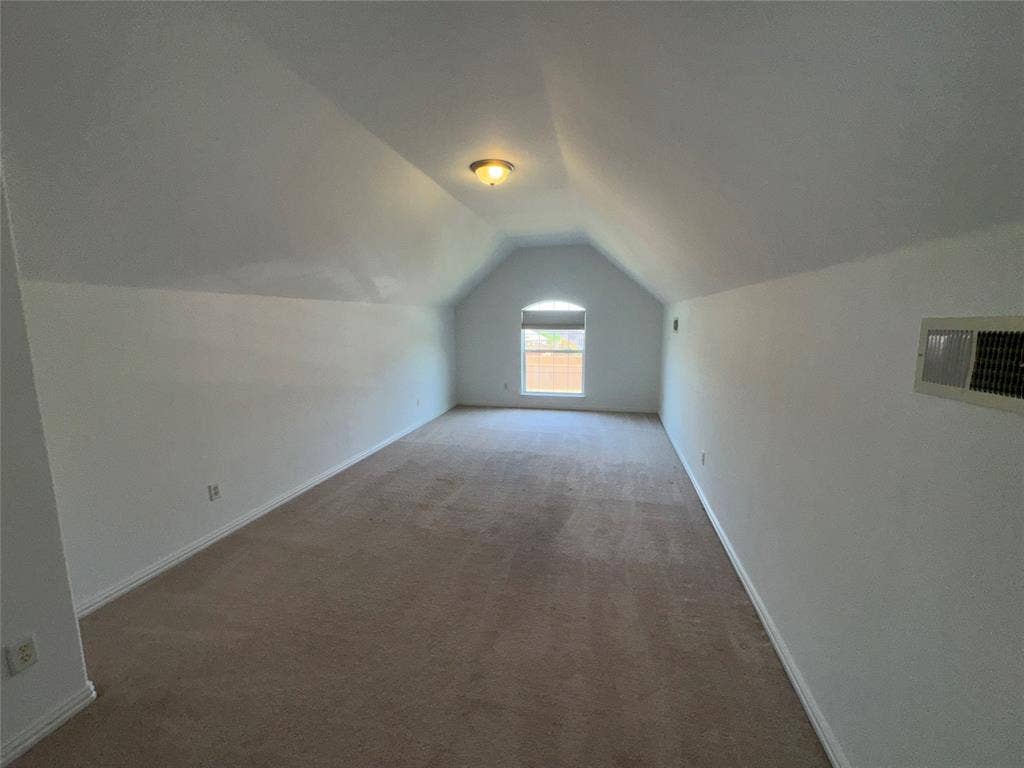 1913 Lawnview Drive, McKinney, TX 75072 Spacious upper-level bedroom featuring vaulted ceilings, recessed lighting, and abundant natural light from a front-facing window