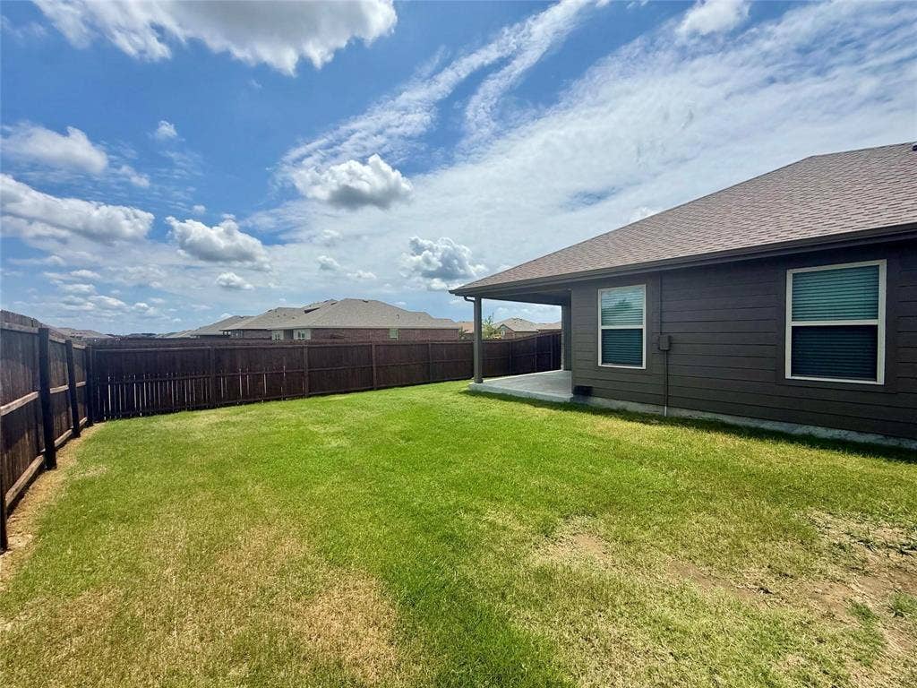 717 Cottonwood Way, Royse City, TX 75189 Expansive backyard featuring a covered patio, privacy fencing, and a large grass lawn