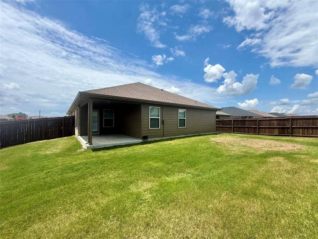 717 Cottonwood Way, Royse City, TX 75189 Expansive backyard featuring a covered patio, privacy fencing, and a large grass lawn