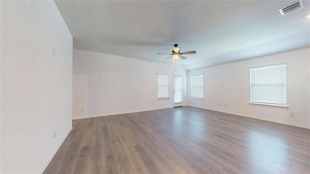 717 Cottonwood Way, Royse City, TX 75189 Spacious room featuring vaulted ceilings, light wood-finish flooring, and crisp white walls