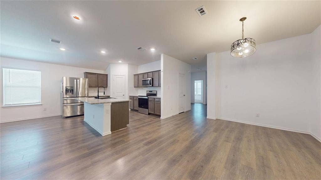 717 Cottonwood Way, Royse City, TX 75189 Open-concept living area with wood-finish flooring, recessed lighting, and a window with blinds