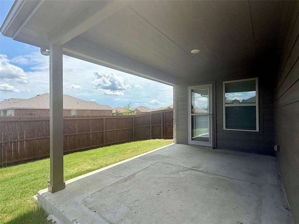 717 Cottonwood Way, Royse City, TX 75189 Covered concrete patio extending into a grassed yard, bordered by a privacy fence